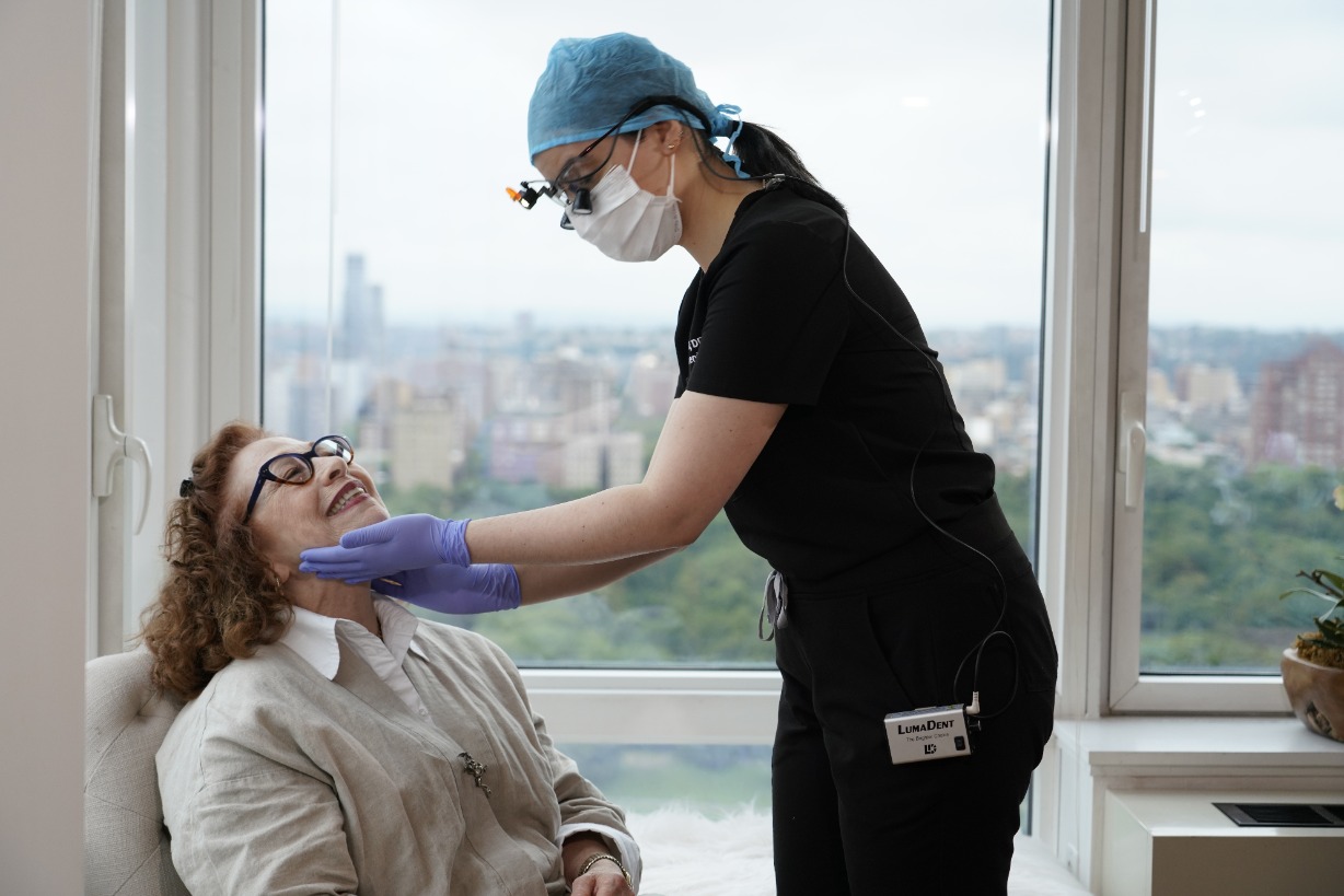 a smiling patient with a house call dentist experiencing in home dental care for seniors